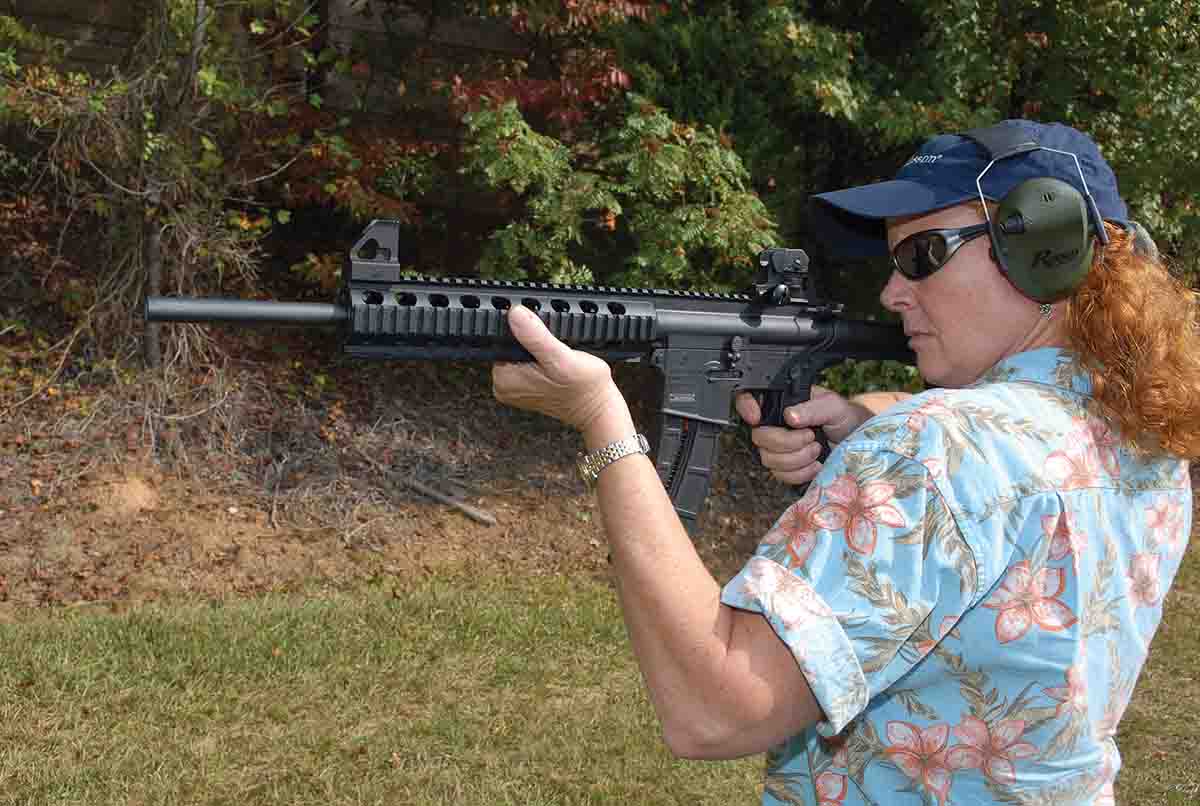 Above, controls and pin locations are identical to a standard AR-15. Amy Brady shoots the rifle with factory sights, which are the same as the latest military versions and can be removed for optical sight use.